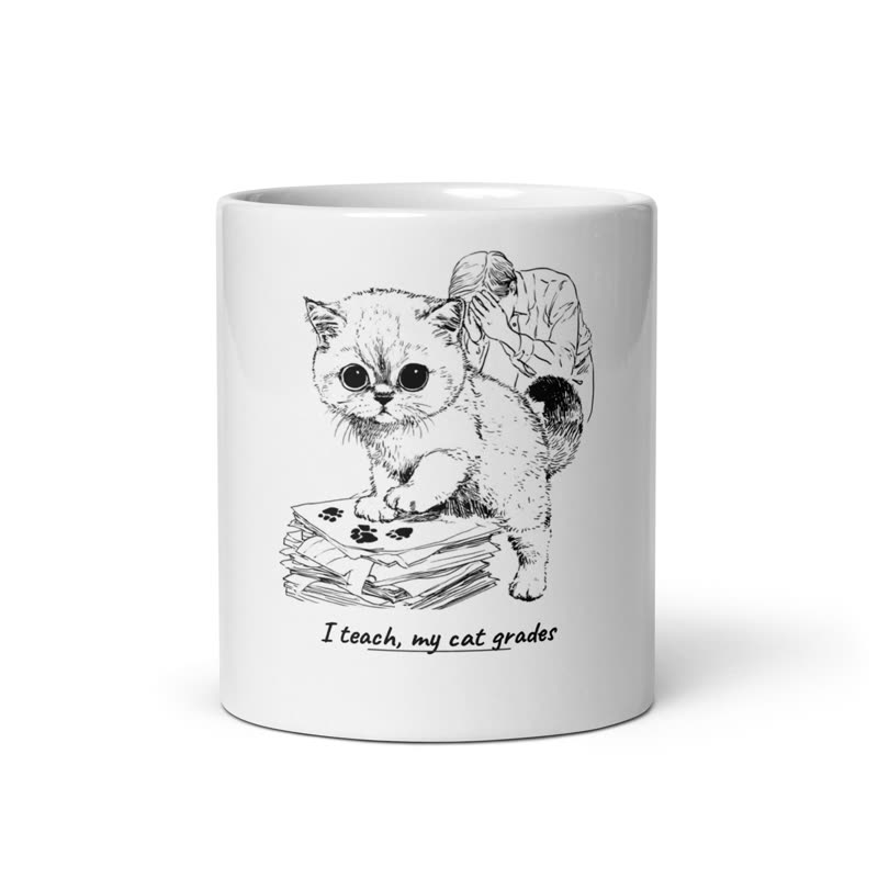 White mug printed with a kitten pressing paw prints onto a stack of papers and the line “I teach, my cat grades”